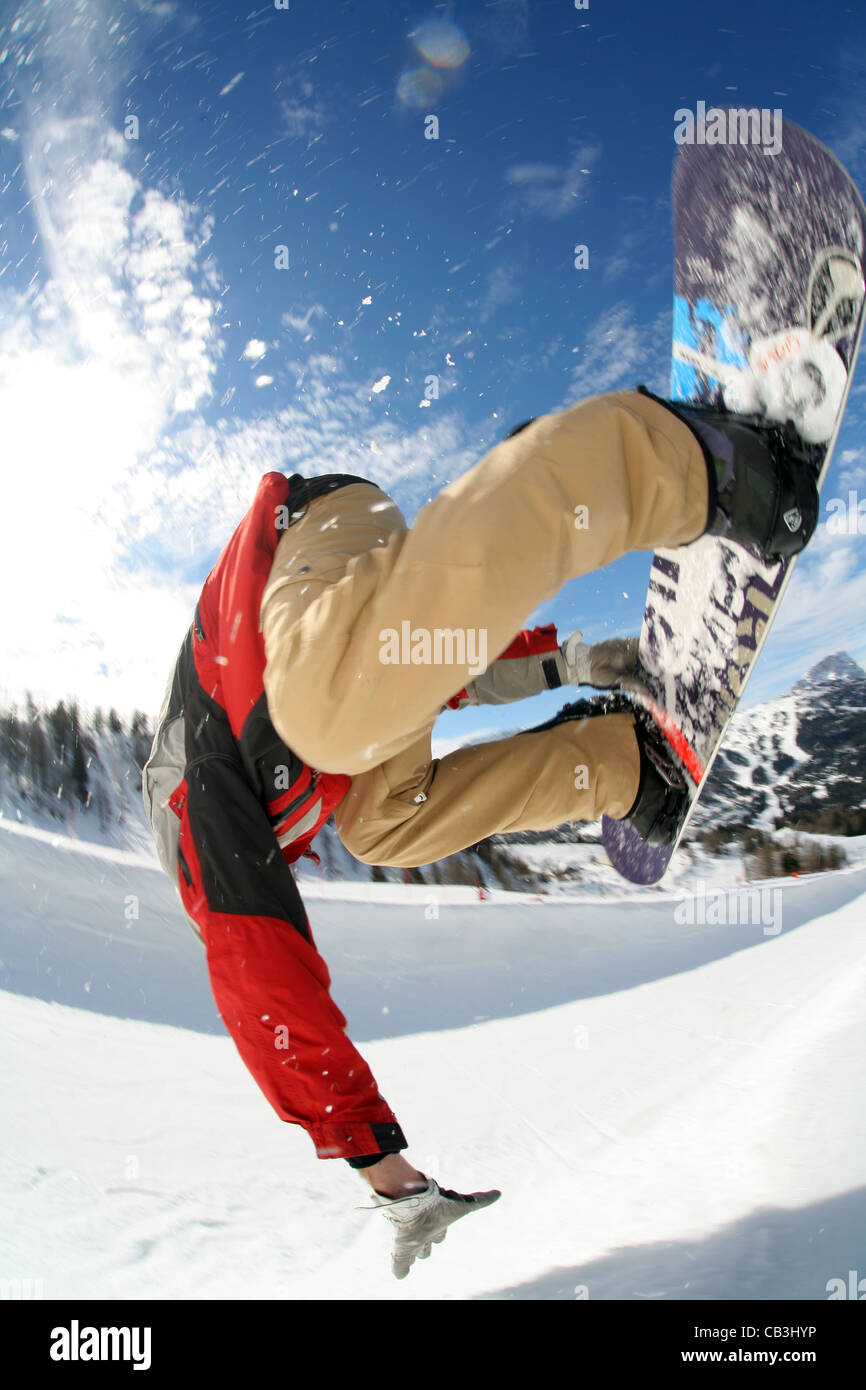 Snowboarder perfoming a trick or stunt close-up on a sunny day in wintersport Stock Photo
