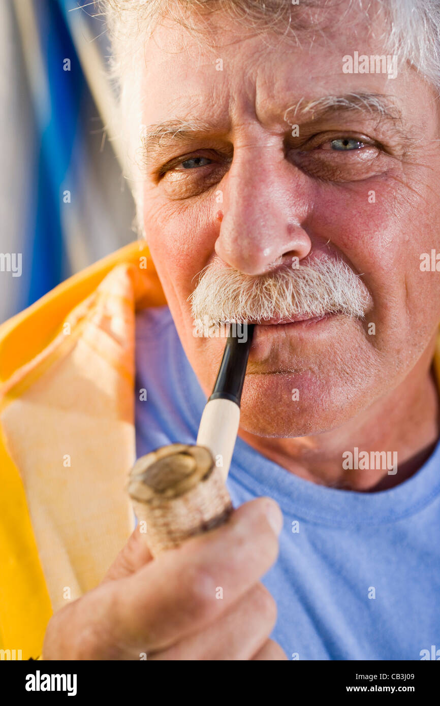 Senior man smoking pipe Stock Photo