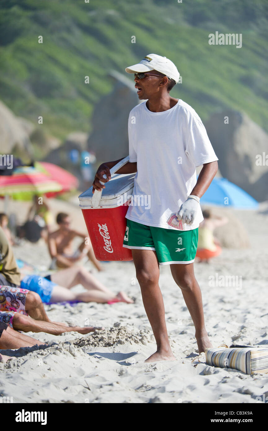 Man with coolbox selling refreshments on Llandudno beach Cape Town South Africa Stock Photo