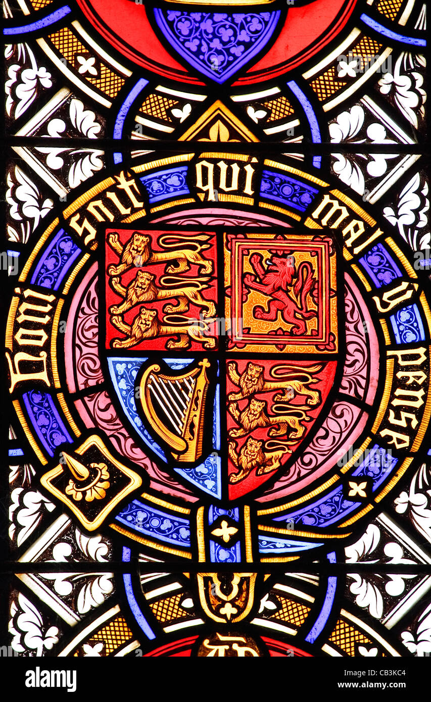 A stained glass window panel in a church depicting a Royal coat of arms and  the motto 'Honi soit qui mal y pense' Stock Photo - Alamy