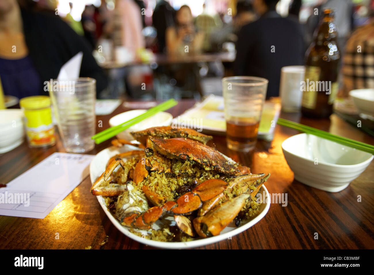 plate of spicy crab seafood at a table in an outdoor market temple street cafe at night kowloon hong kong hksar china Stock Photo