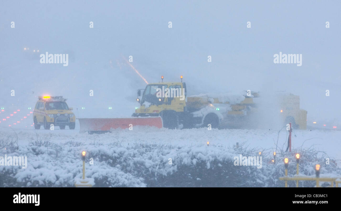 Snowploughs battle to clear thick snow from London Gatwick Airport's runway during a blizzard. Stock Photo