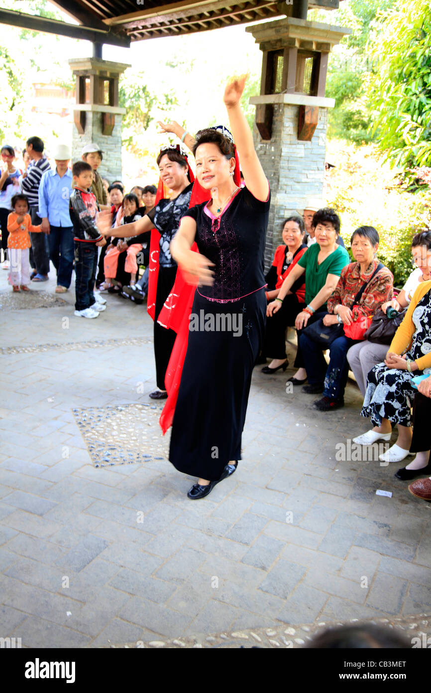 China, Kunming, Women dancing in front of audience Stock Photo