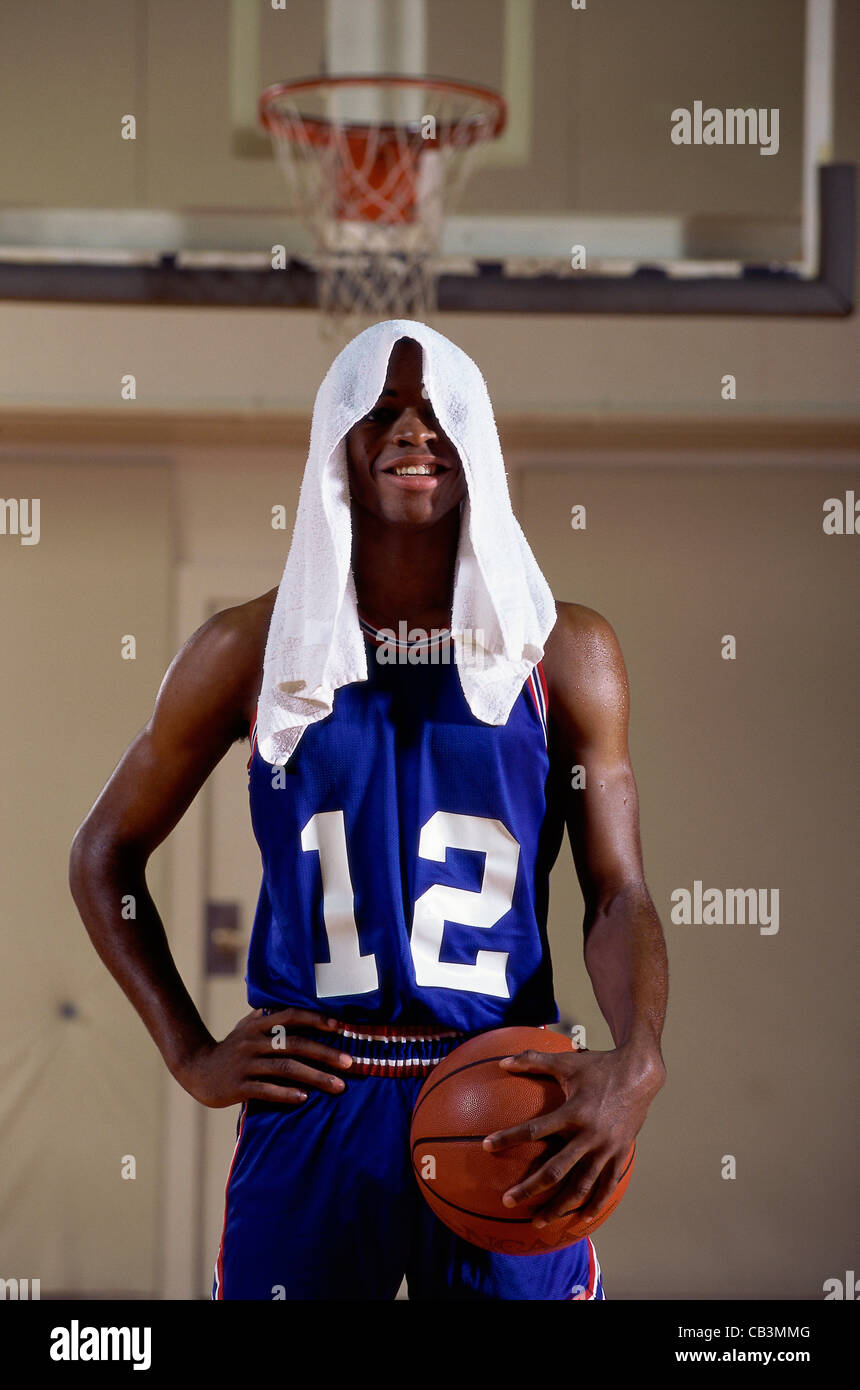 Young man standing holding a basketball with a towel on his head Stock  Photo - Alamy