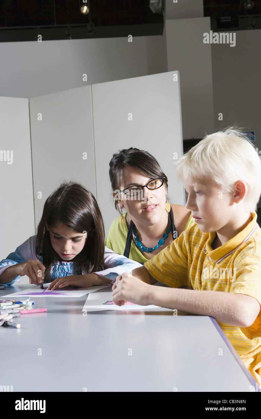 An art teacher teaching young students in art class Stock Photo - Alamy