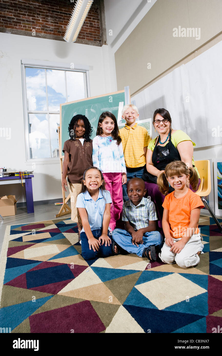Portrait of an art teacher posing with her students Stock Photo - Alamy