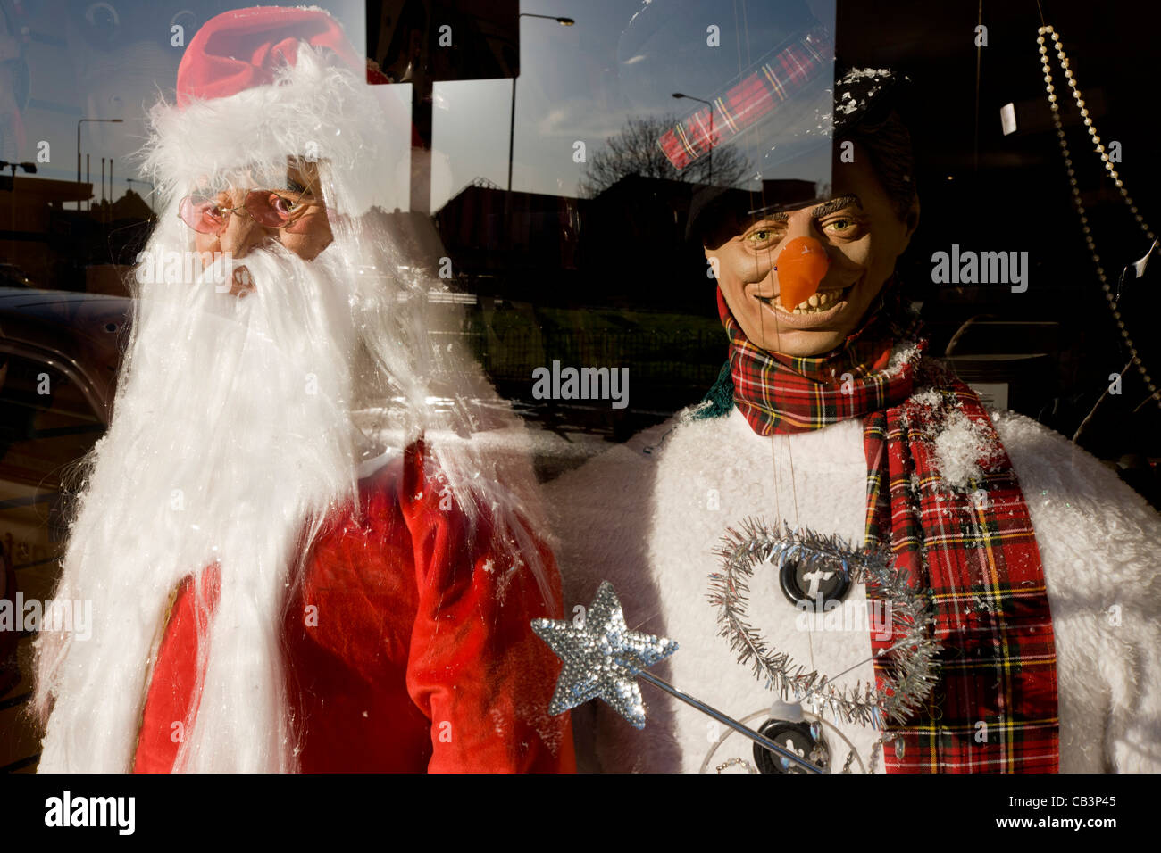 Santa and snowman Christmas party costumes are displayed in the front window of a fancy dress shop in Goven Hill, south Glasgow. Stock Photo