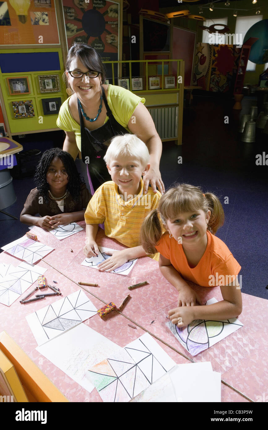 An art teacher teaching her young students in art class Stock Photo - Alamy