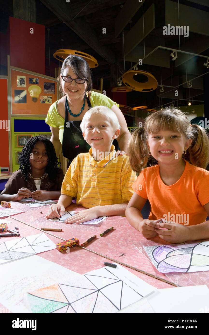 An art teacher teaching her young students in art class Stock Photo - Alamy