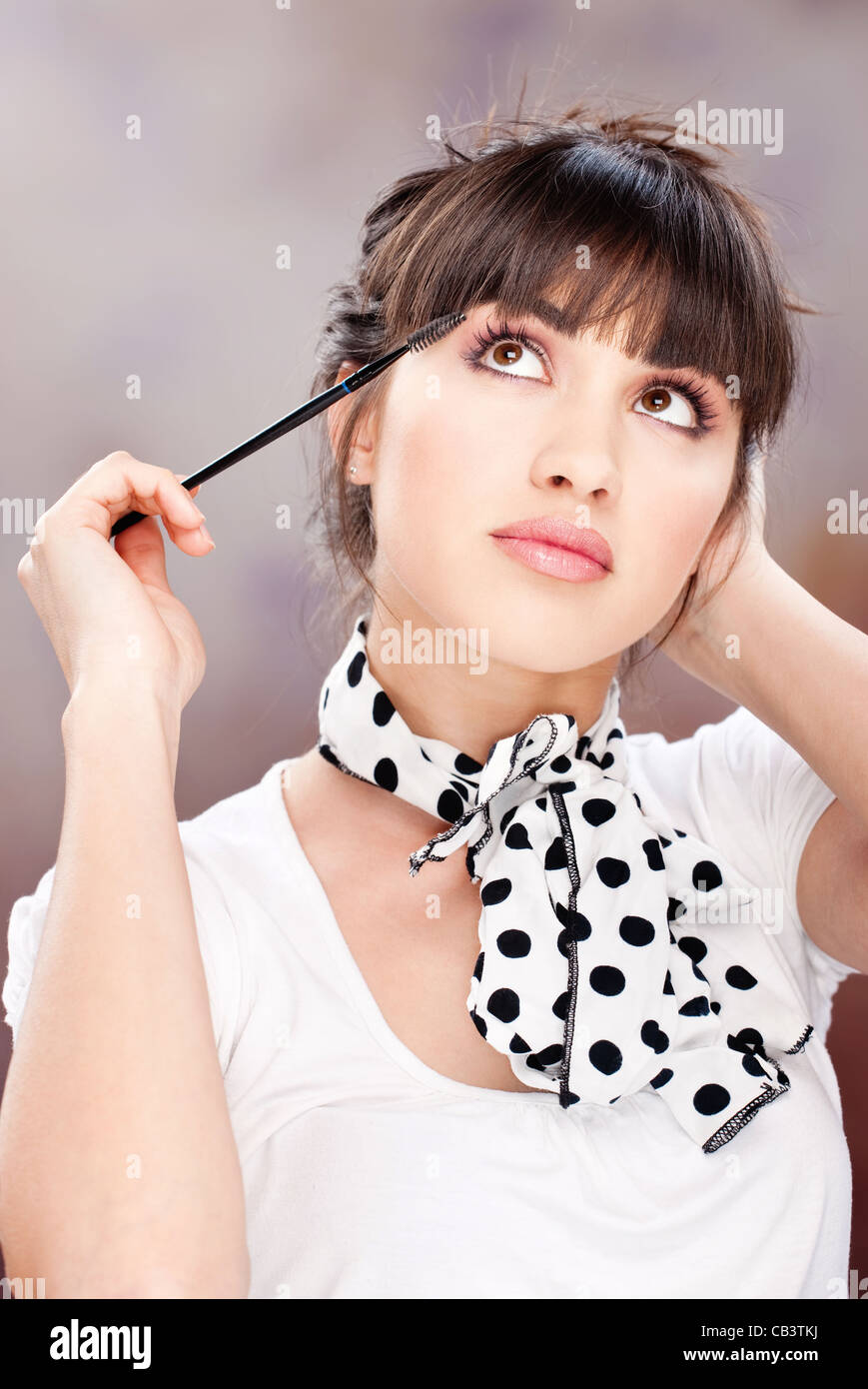 Pretty woman applying makeup on eyelash Stock Photo