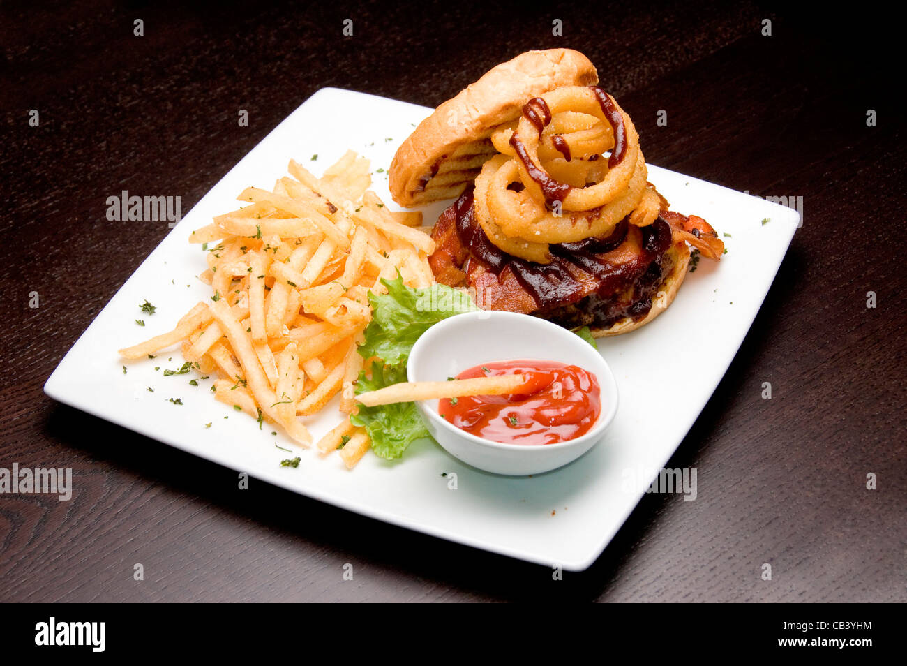 High angle view of French fries and a burger with a bowl of ketchup ...