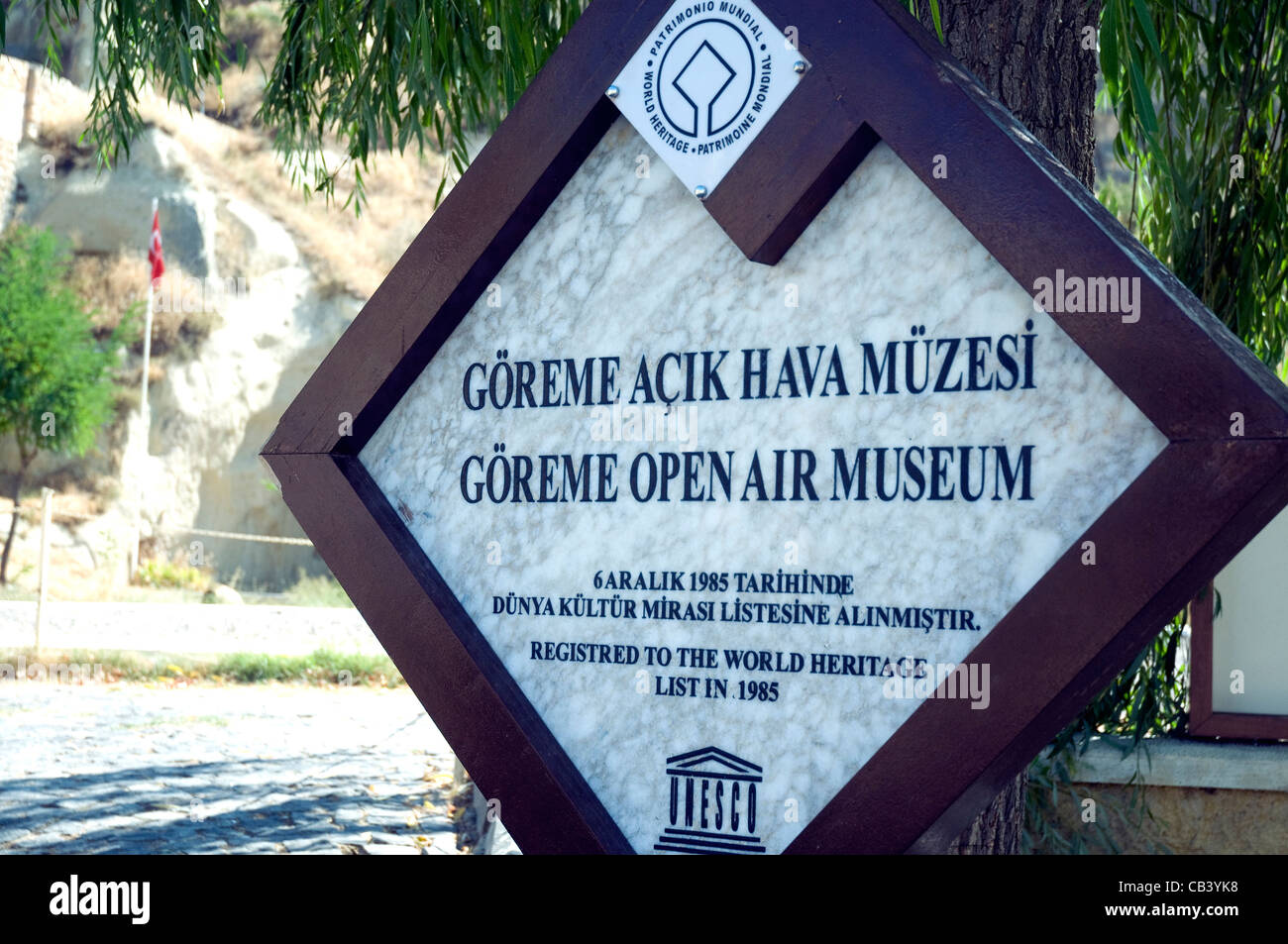 The sign for the Goreme Open Air museum of tufa rock formations in Cappadocia records its World Heritage Site listing Stock Photo