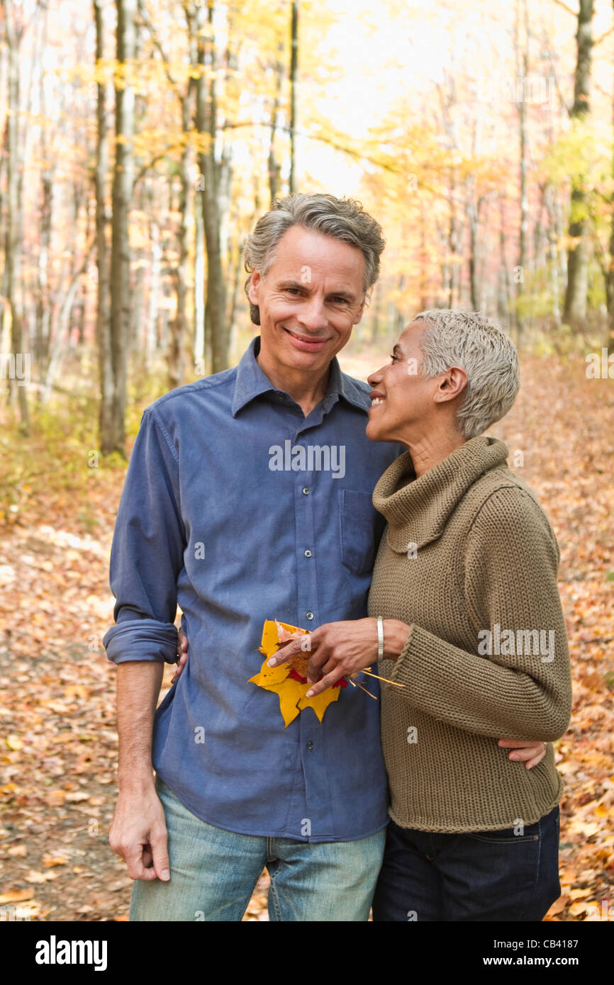Mature couple holding Autumn leaves in forest Stock Photo - Alamy
