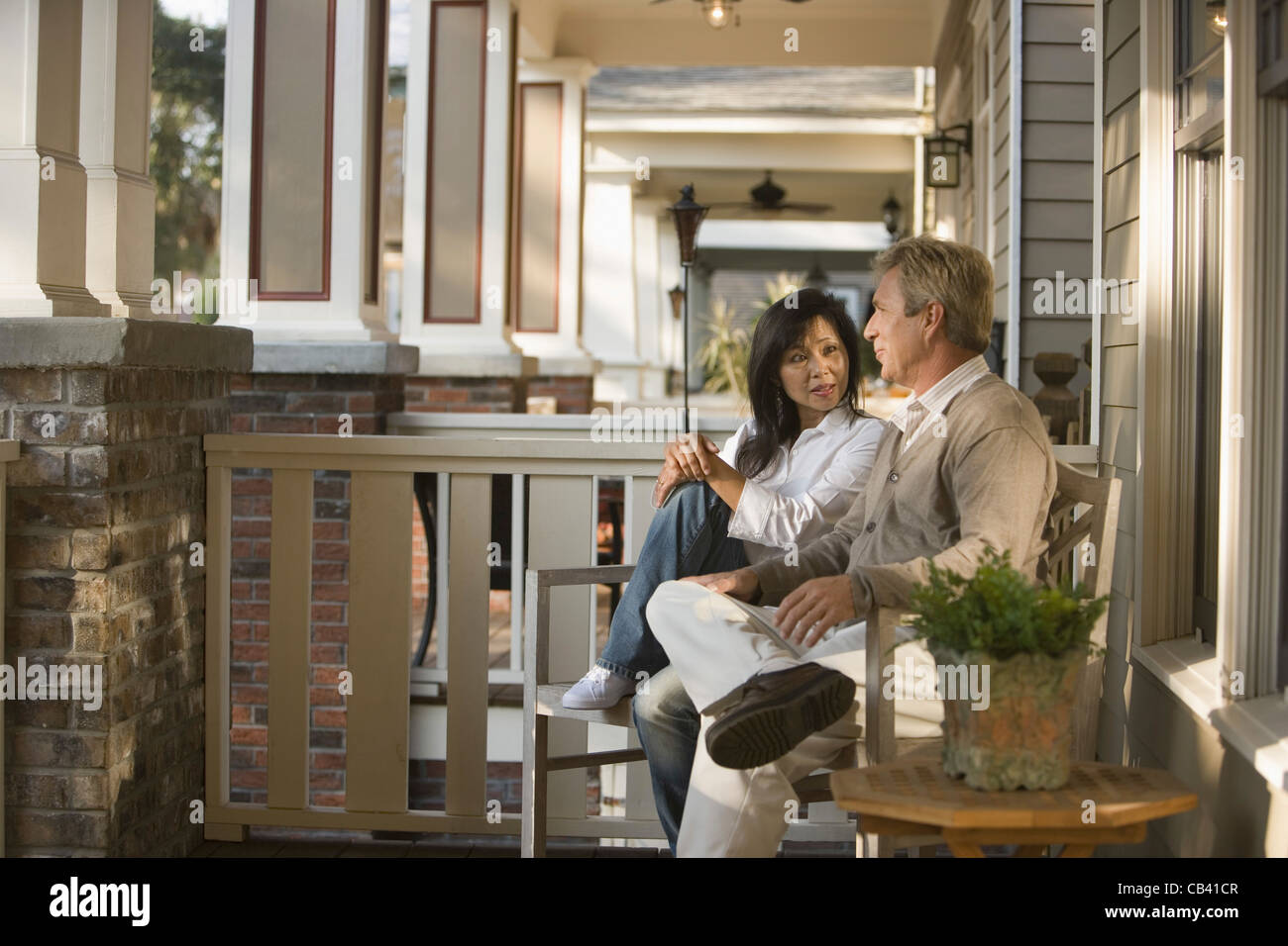 Mature interracial couple sitting on front porch of their house Stock Photo Alamy
