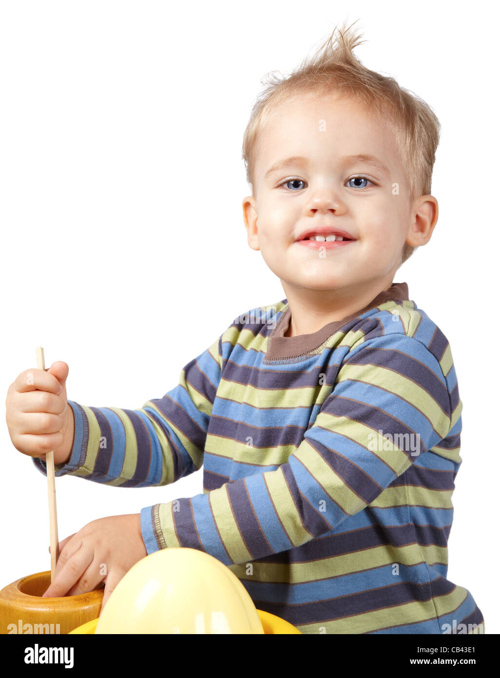 Studio portrait of a happy one year old baby boy playing with kitchen
