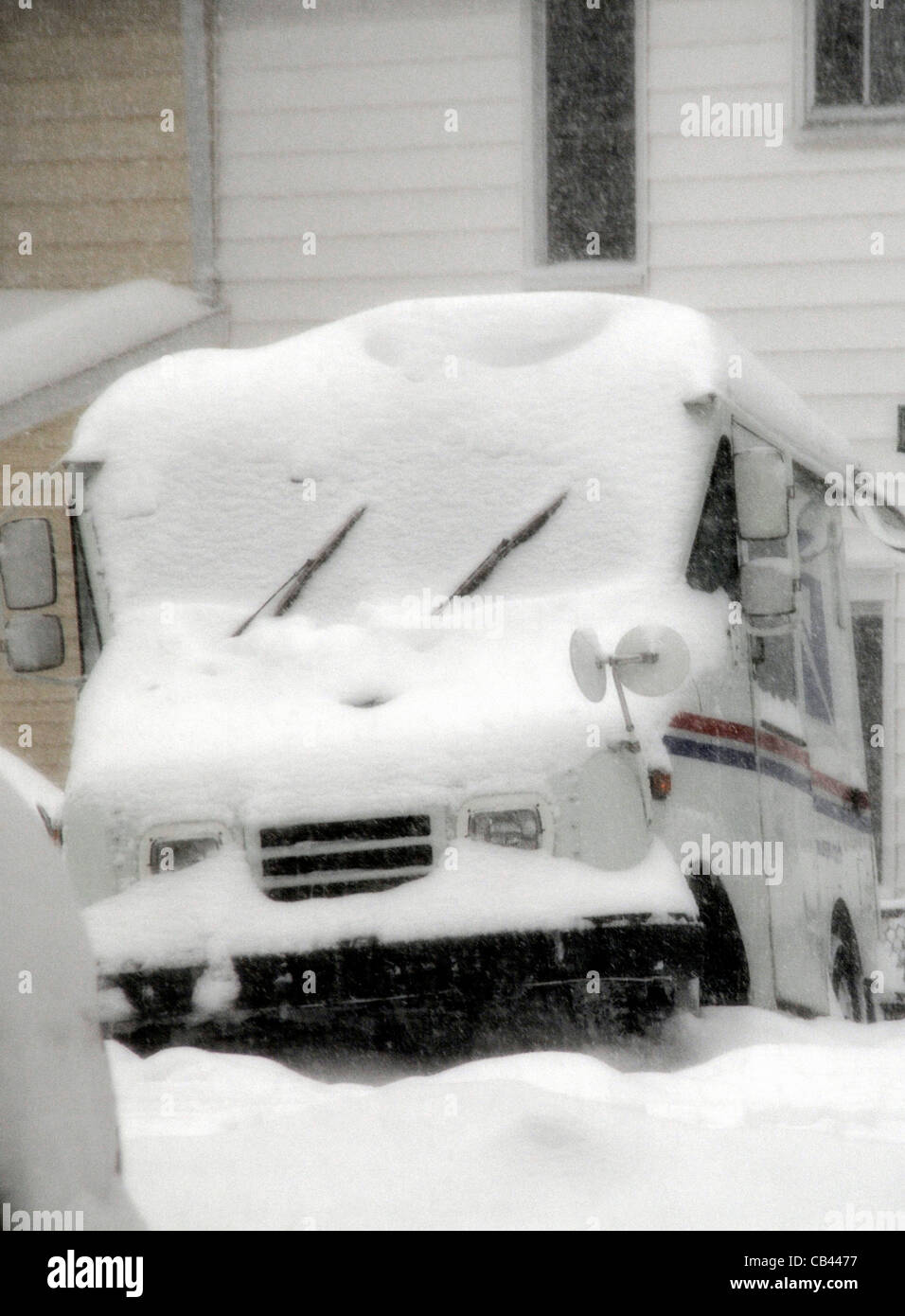 a US mail truck is parked while the mailman makes his rounds during a blizzard in Greenbelt, Maryland Stock Photo