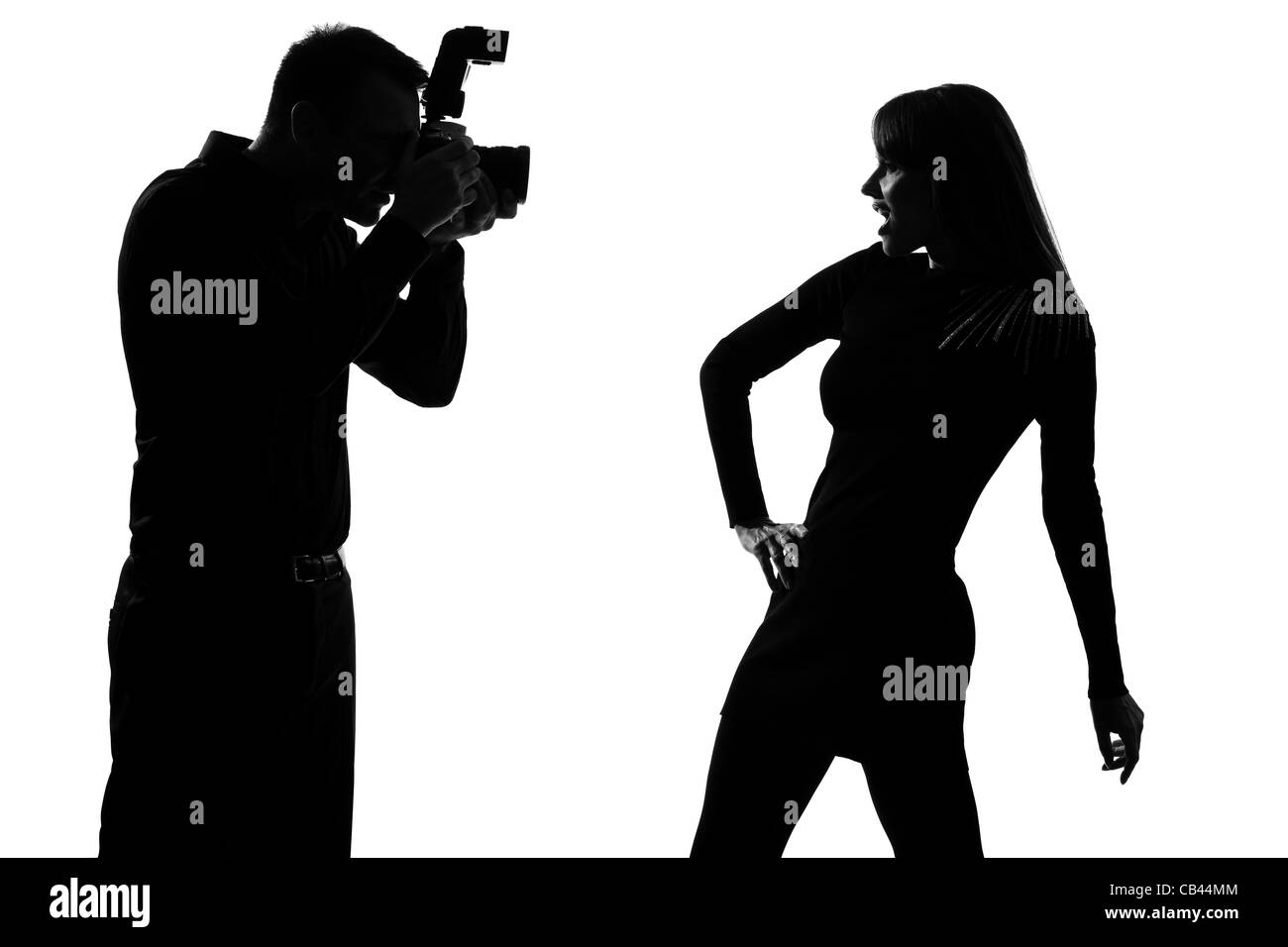 one caucasian  couple man photographer photographing and woman fashion model posing in studio silhouette isolated on white background Stock Photo