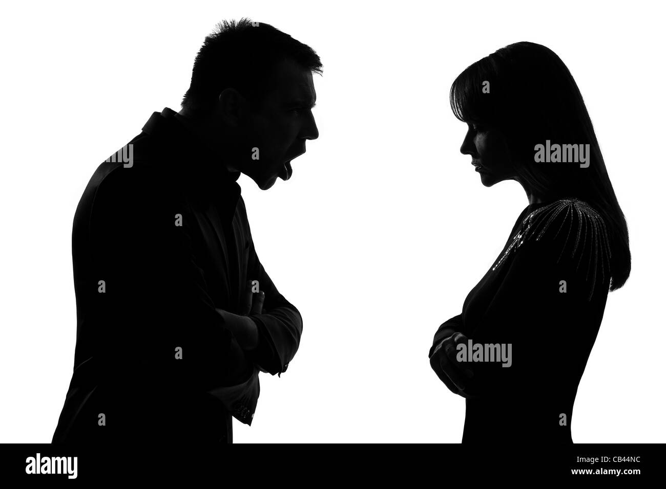 one caucasian couple man and woman face to face screaming shouting dipute in studio silhouette isolated on white background Stock Photo