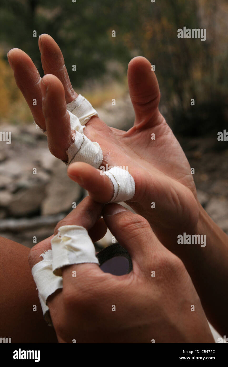the hands of a female climber taping her fingers before climbing Stock Photo