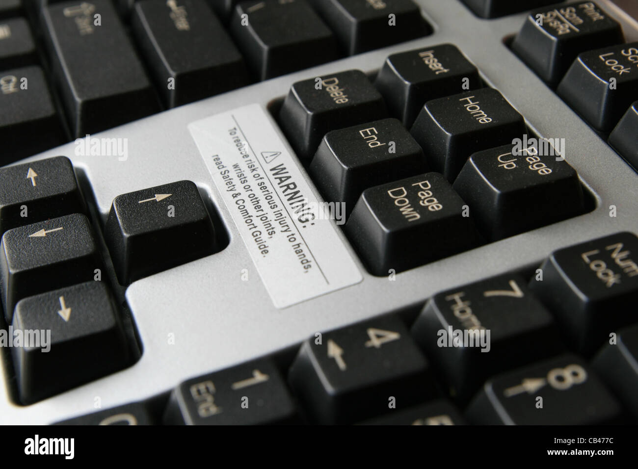 close up of carpal tunnel warning on gray and black computer keyboard Stock Photo