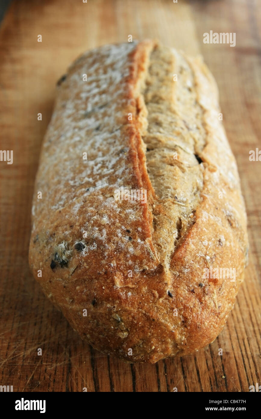 vertical view of rosemary kalamata olive bread on wooden cutting board Stock Photo
