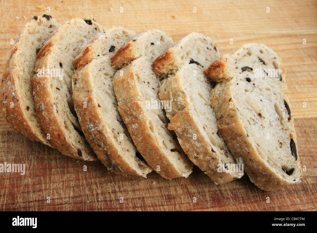 rosemary kalamata olive bread slices on wooden cutting board Stock Photo