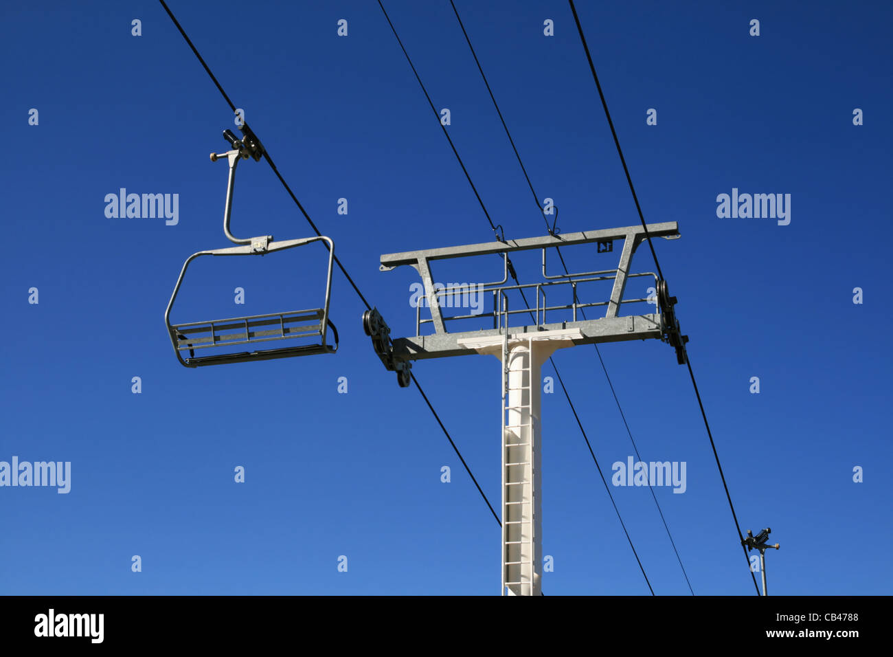 empty ski lift and tower with a blue sky background Stock Photo