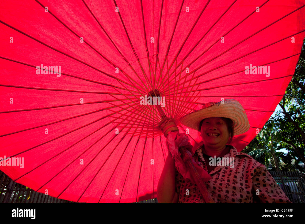 Thailand, Chiang Mai, Borsang Umbrella Village, Workers Carrying Giant Umbrellas Stock Photo