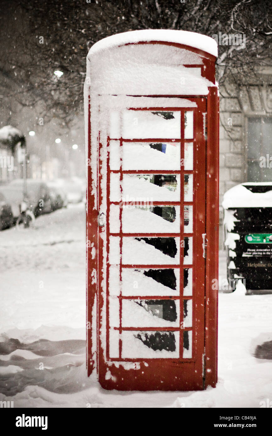 London Snow: A snow covered traditional red British telephone box in Pimlico, London, UK Stock Photo