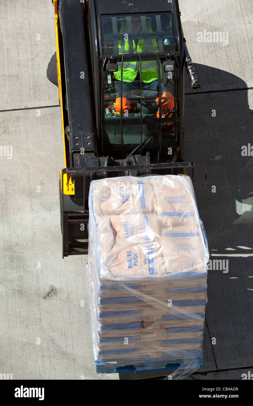 Forklift lifting bakers flour to load on board passenger ship Southampton Docks Stock Photo