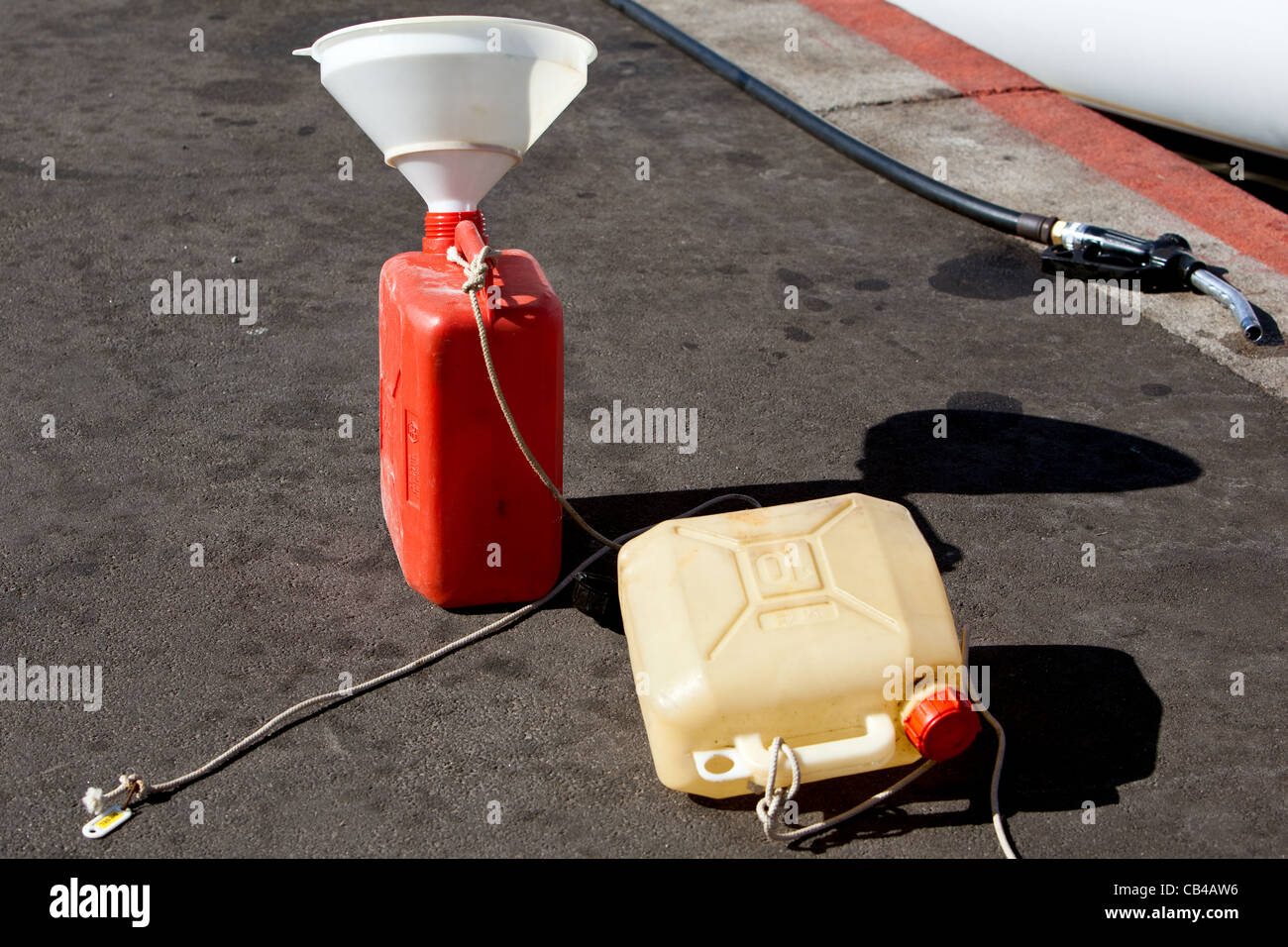 Empty plastic fuel containers on the jetty next to discarded fuel nozzle  at Ajaccio Corsica Stock Photo