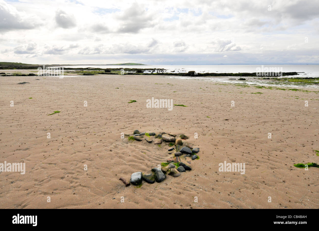Arch of pebbles on sandy Fifeshire beach Stock Photo Alamy