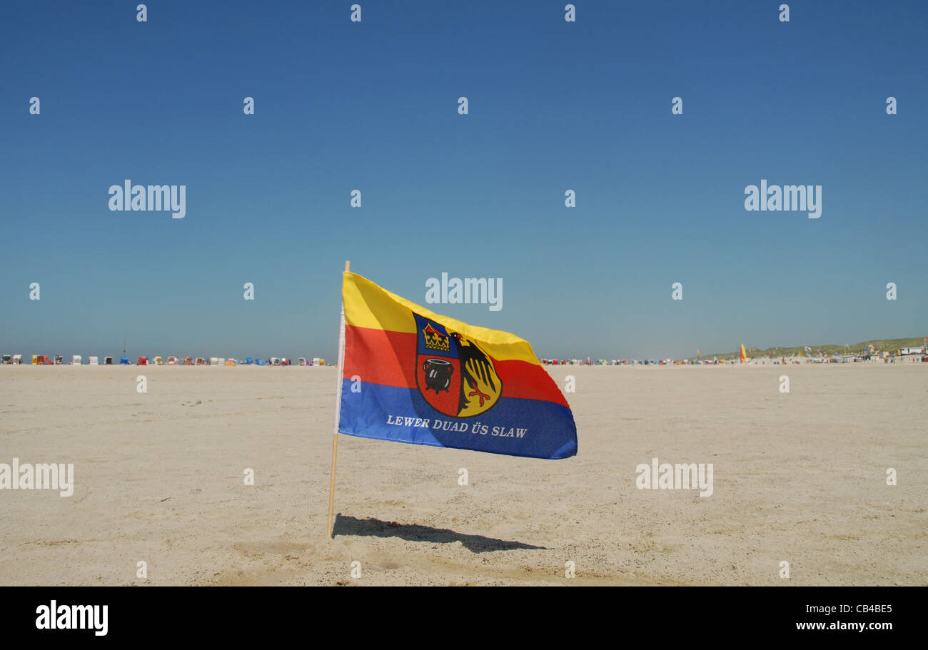 Flag of Northern Frisia stuck in the sand of Kniepsand beach at Norddorf on the North Sea island of Amrum in Schleswig-Holstein Stock Photo