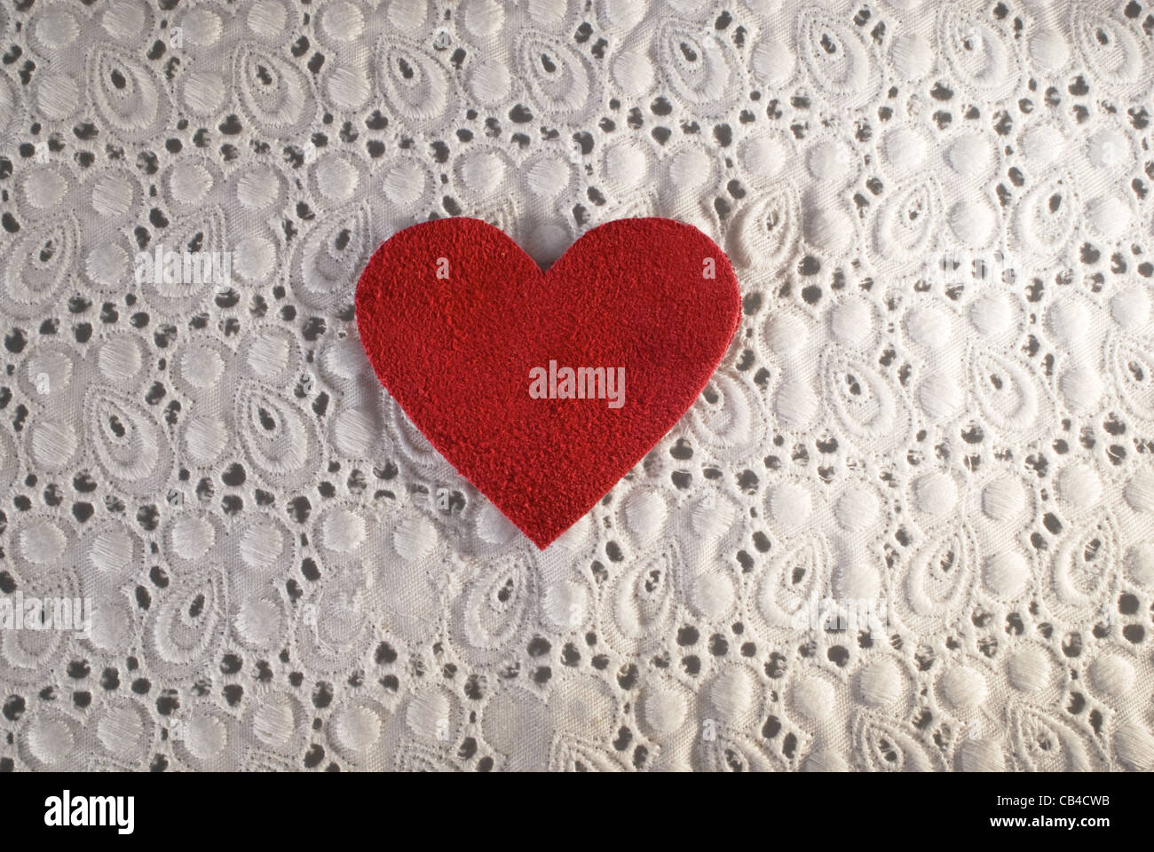 Retro Love. White fabric and red heart shape conceptual composition. Macro texture close up useful as background for design works. Stock Photo