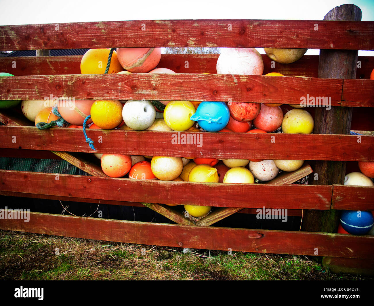 Colourful fishing net floats behind fence Stock Photo Alamy
