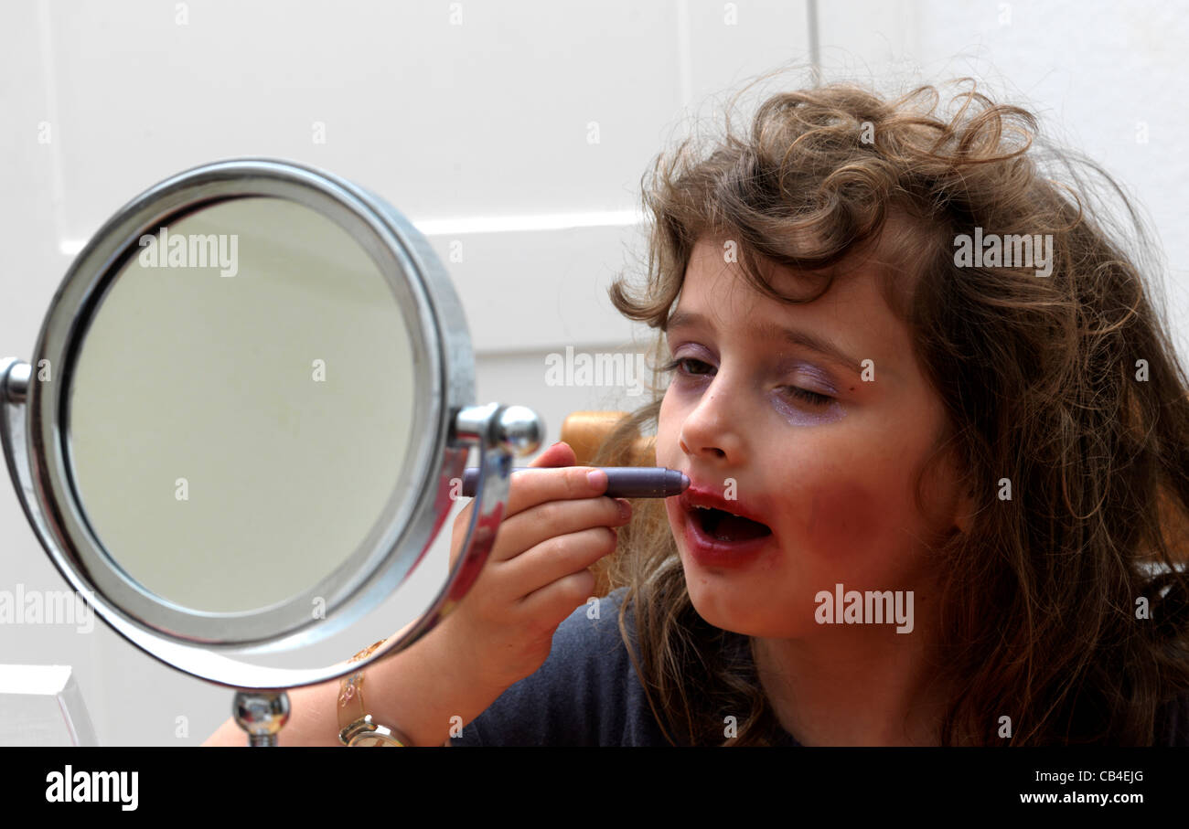 Young Girl Playing Putting Make Up On In Front Of Mirror England Stock Photo