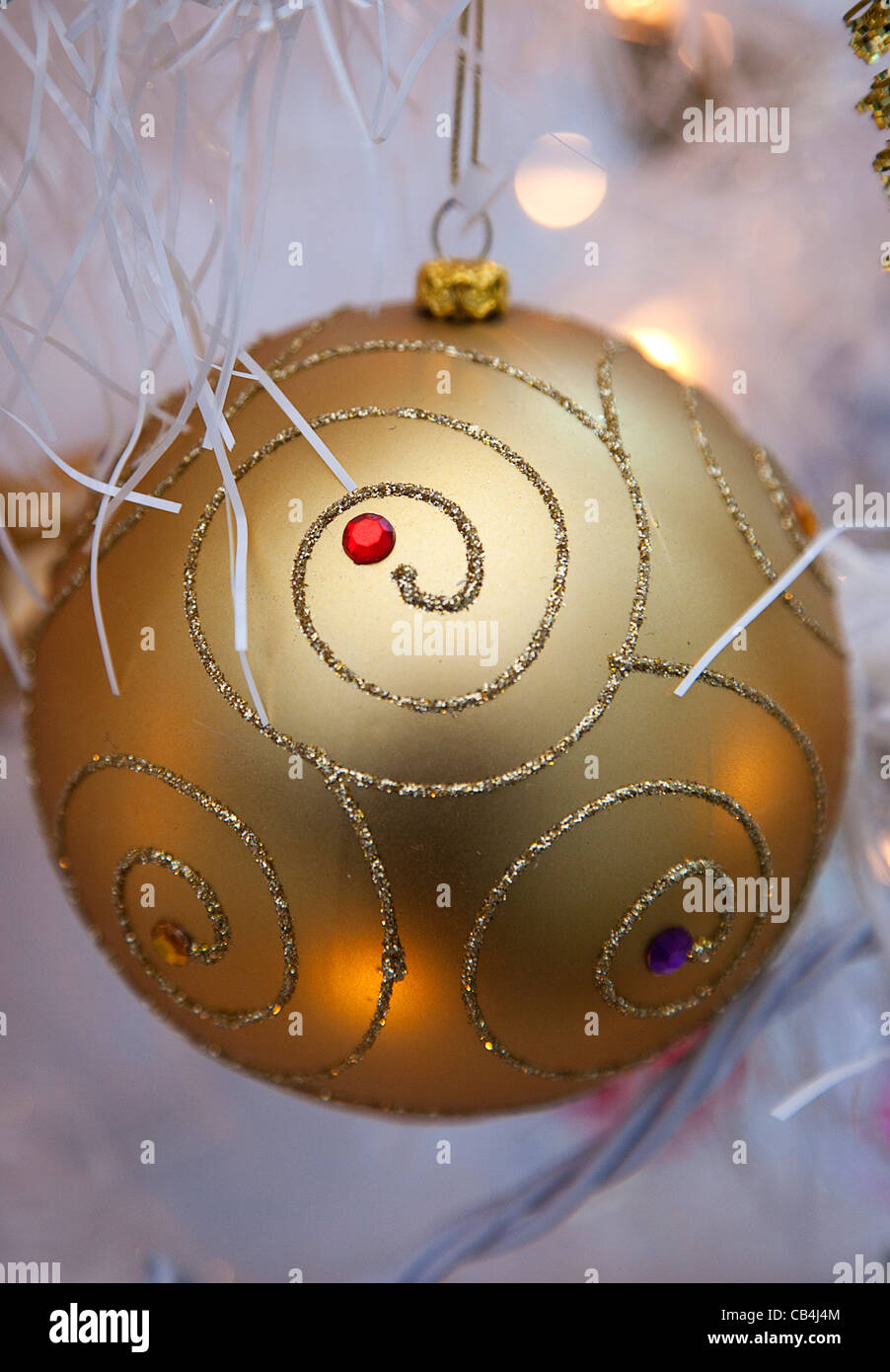 Festivals, Christmas, Decorations, gold coloured, bauble with white tinsel and fairy lights. Stock Photo