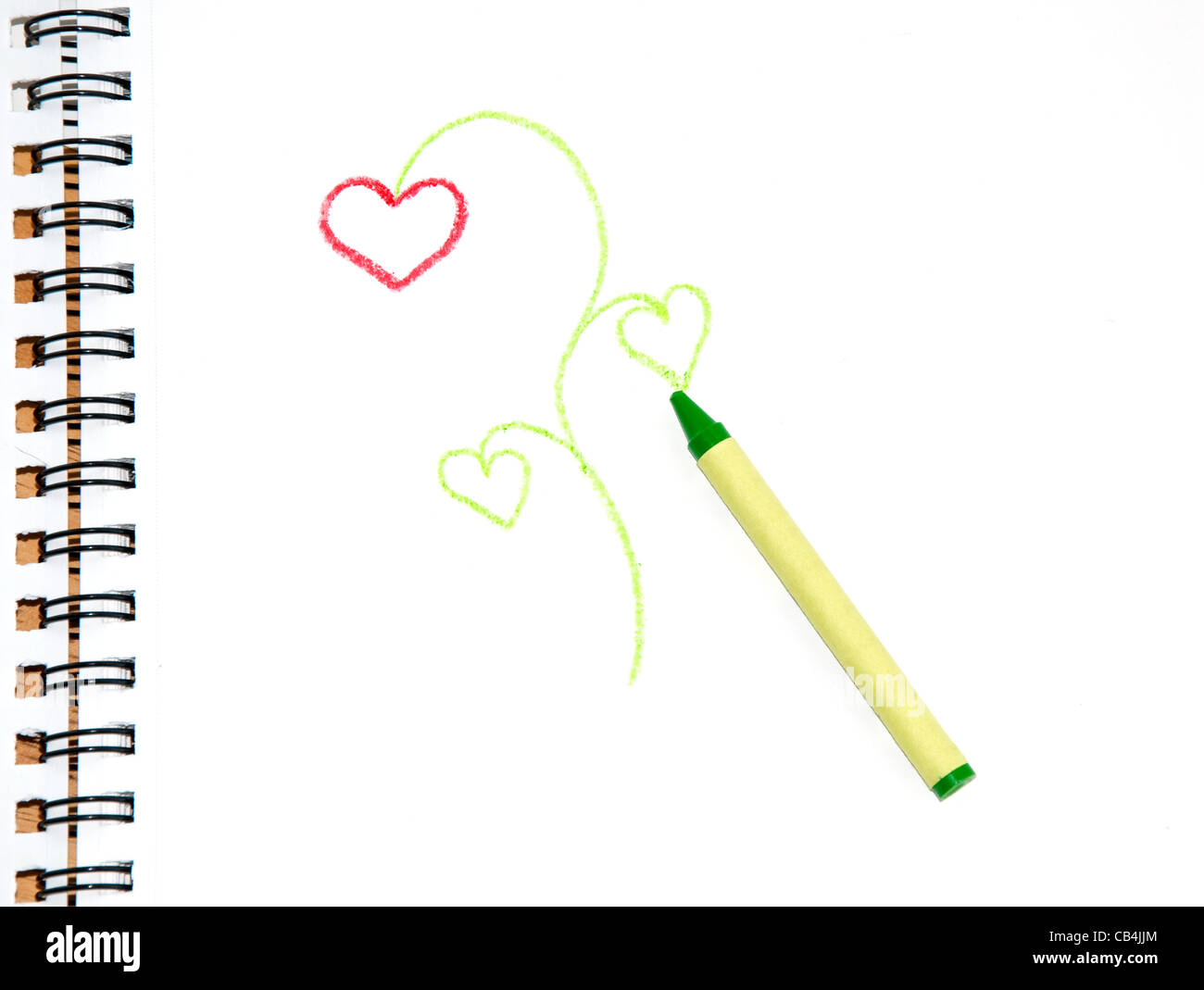 Green crayon on sketch paper with a doodle of a plant with heart shaped flower and leaves Stock Photo