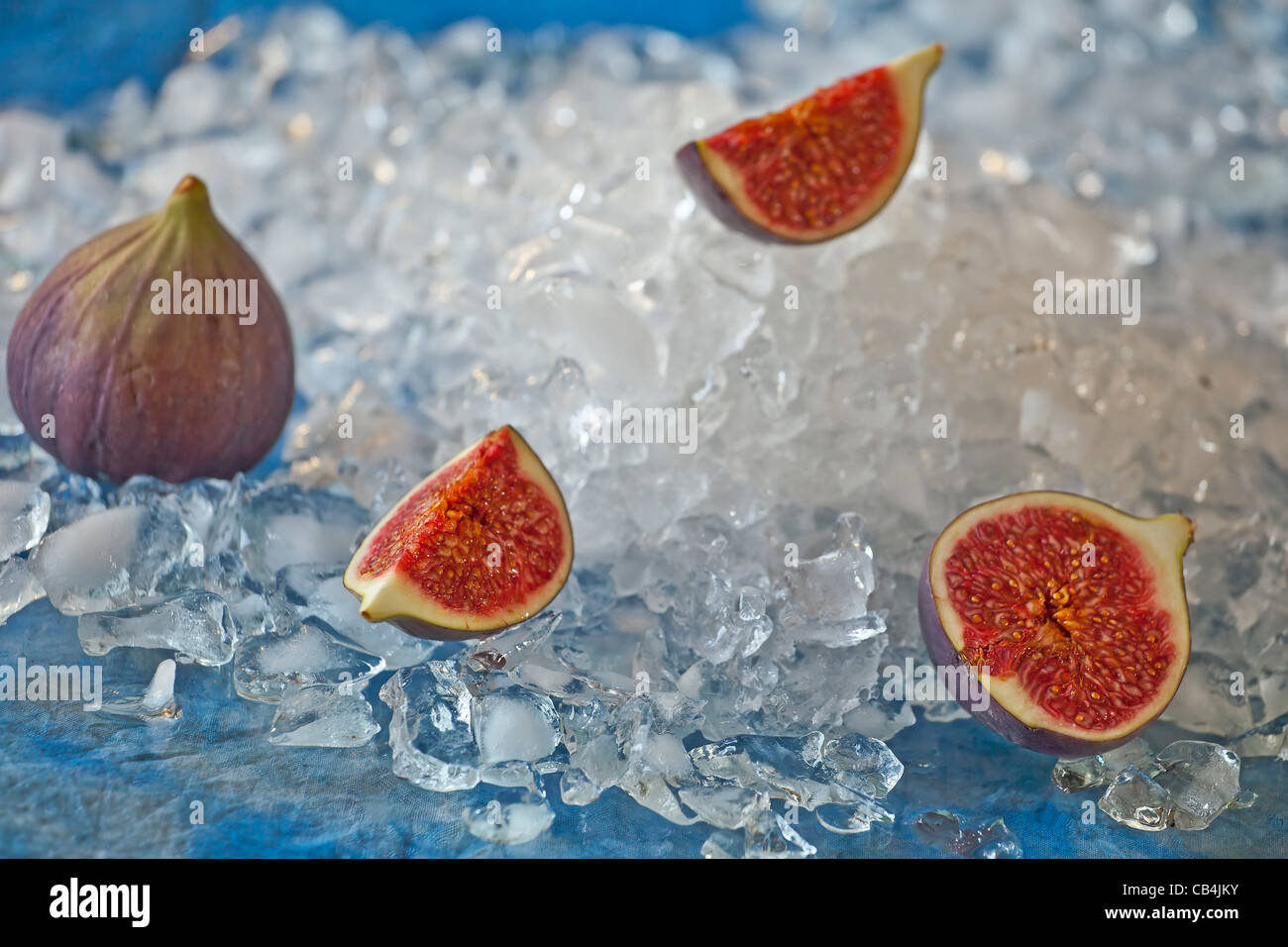 a whole figs and a cut fig on crushed ice Stock Photo