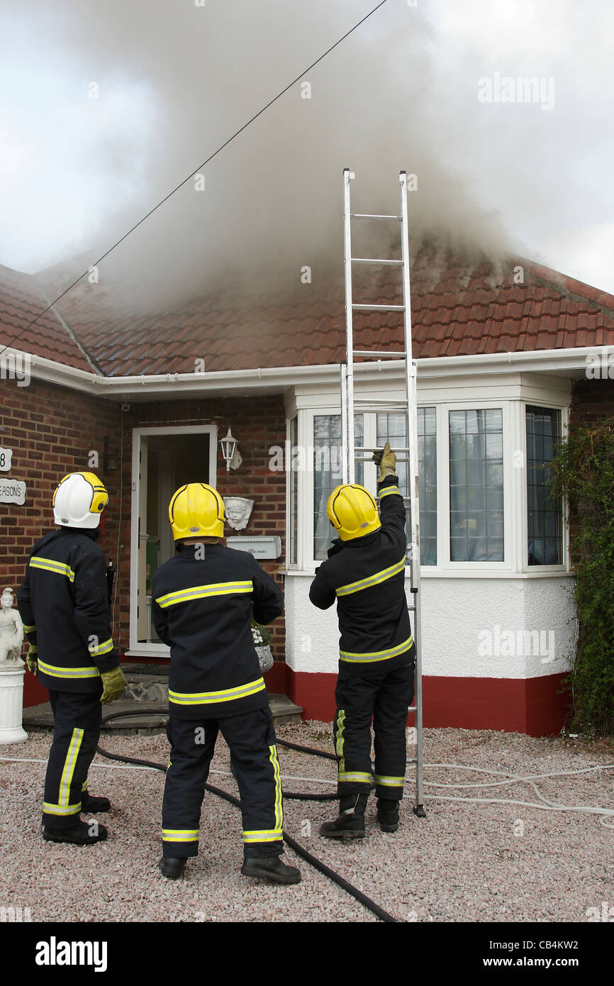 Firefighters arrive at the scene of a fire in the roof of a bungalow