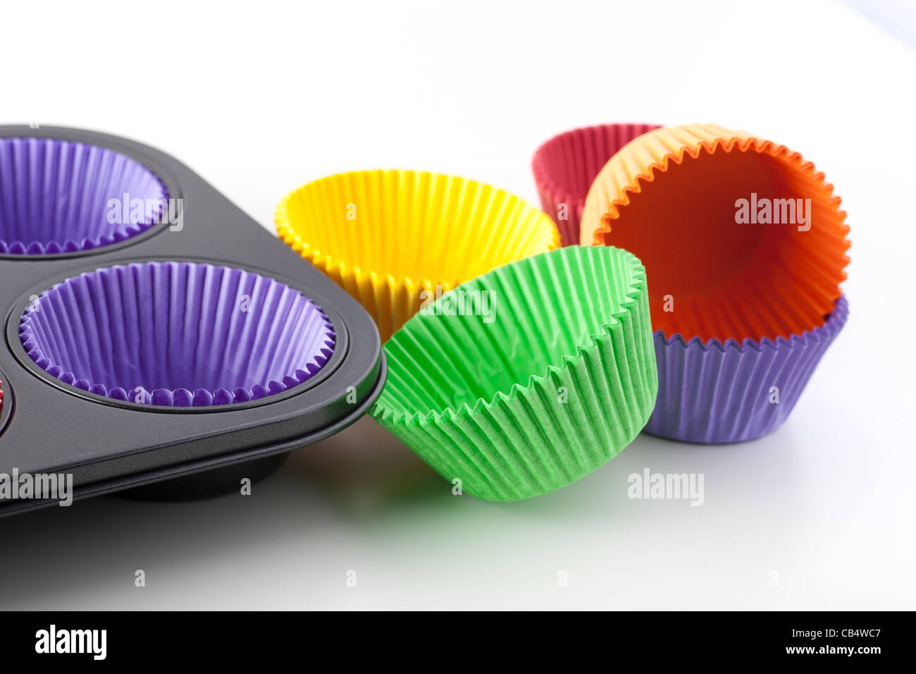 Colorful cupcake papers and muffin pan ready for baking. Stock Photo