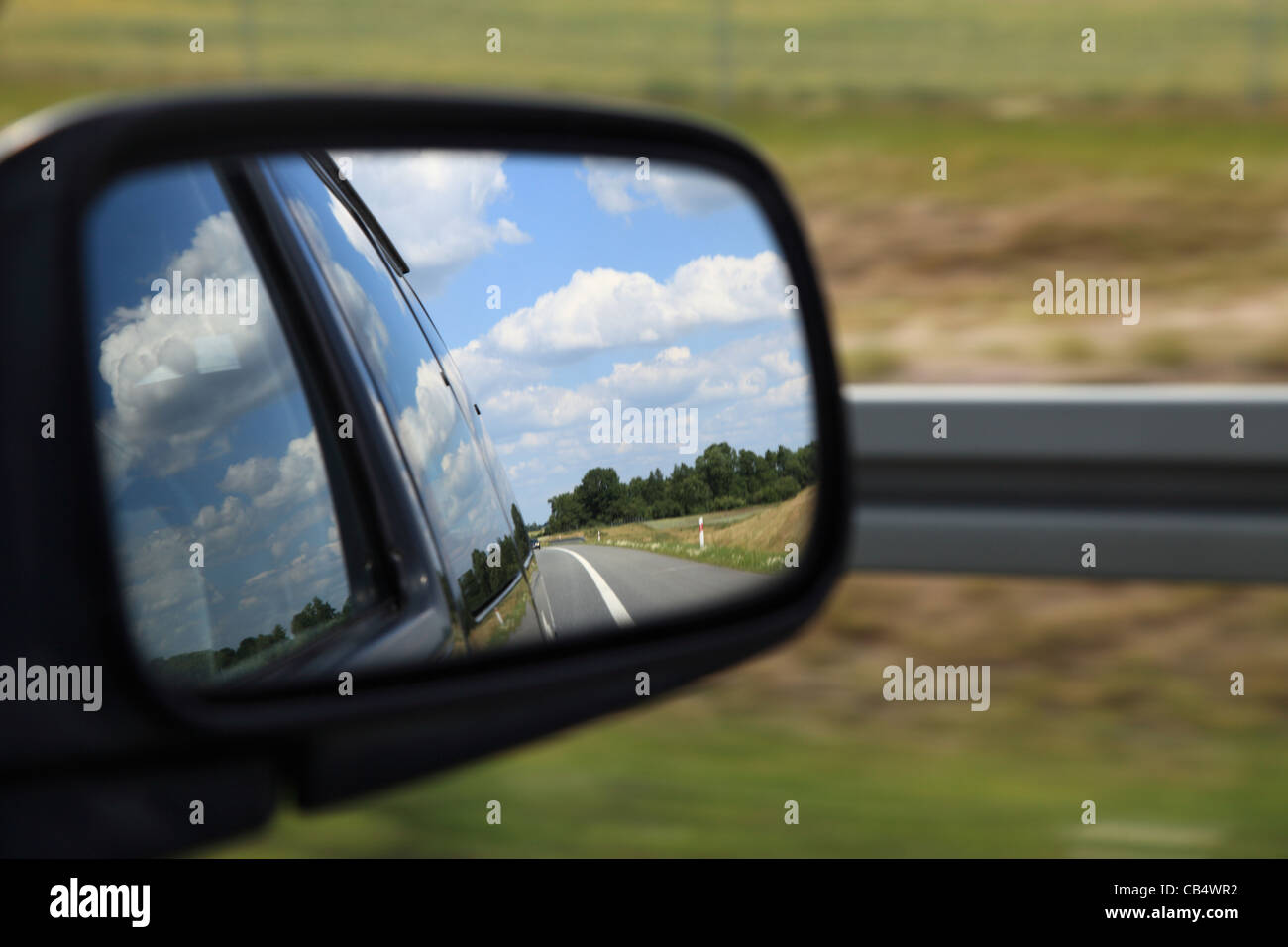 Road reflecting in the sideview mirror of a car Stock Photo