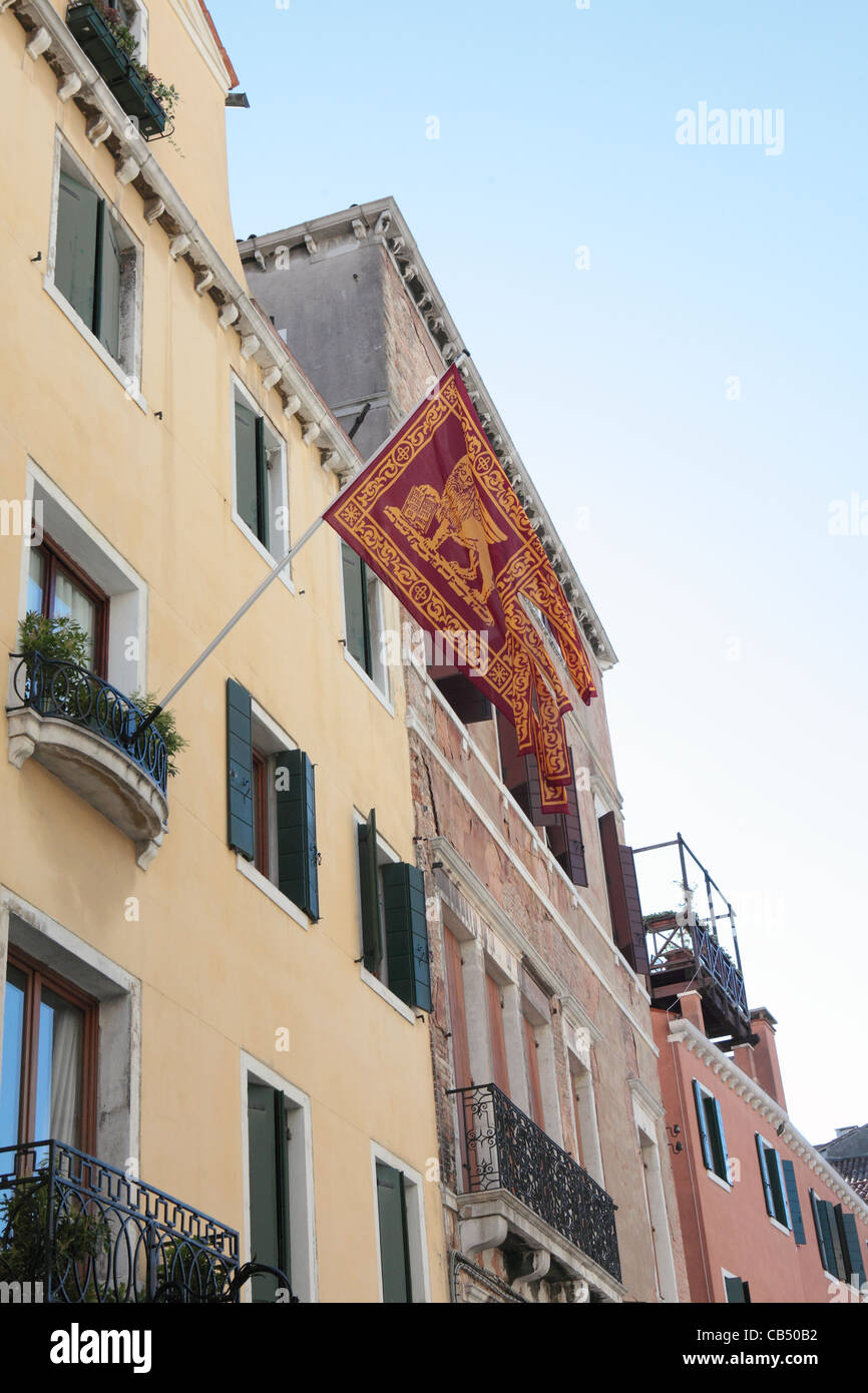 An ancient house in Venice flies the flag of the Serene Republic - the Lion of St Mark Stock Photo