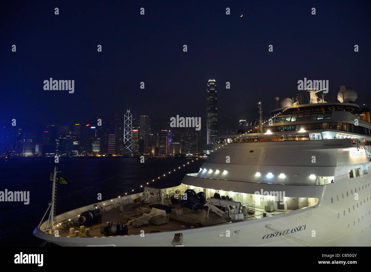 A modern cruise ship in front of HongKong harbor skyline, China SAR Stock Photo