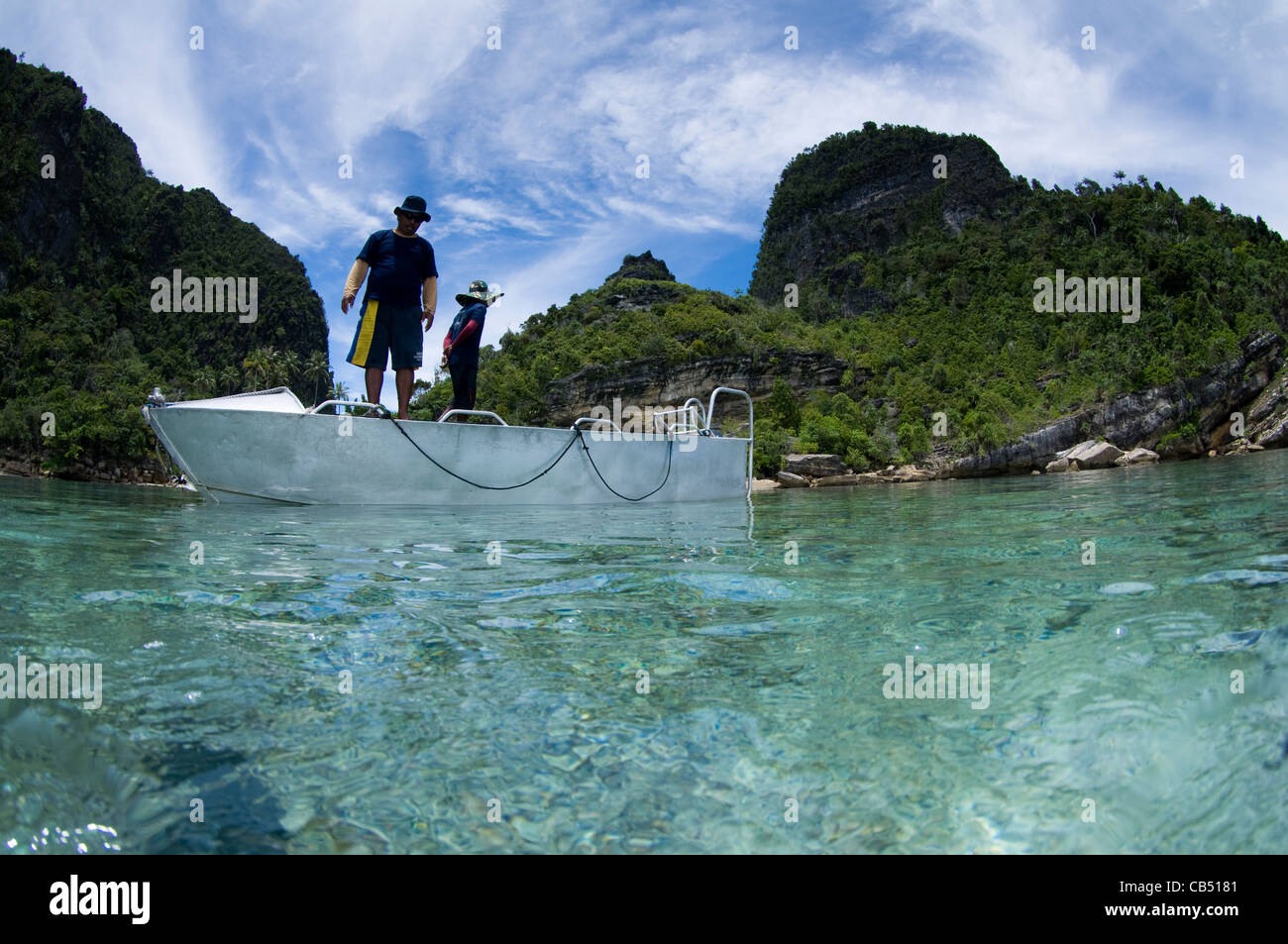 Two men on a boat, Split level photo, Misool area, Raja Ampat, West Papua, Indonesia, Pacific Ocean Stock Photo