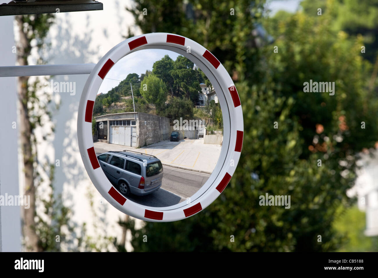 Car reflected in road traffic safety mirror to increase visibility in Croatia Stock Photo