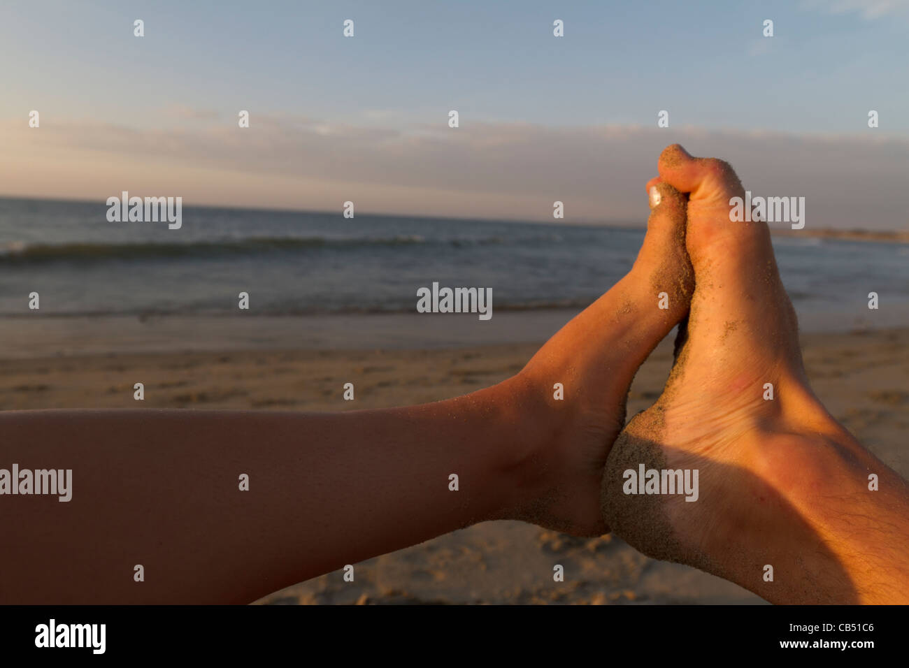 Man and girl feet together on beach Stock Photo Alamy