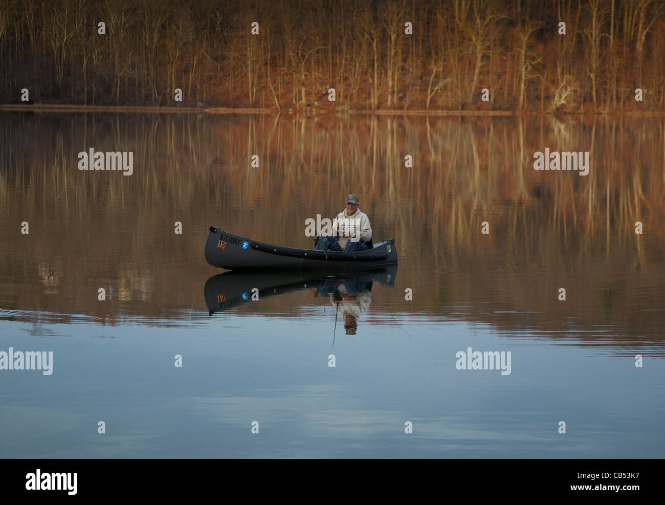 A man fishing from a canoe Stock Photo - Alamy