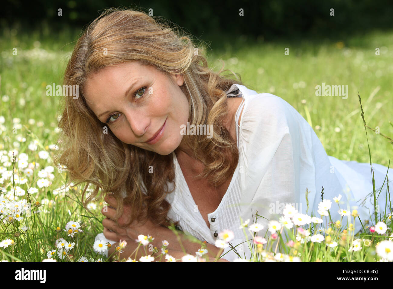 Woman lying in a meadow Stock Photo - Alamy