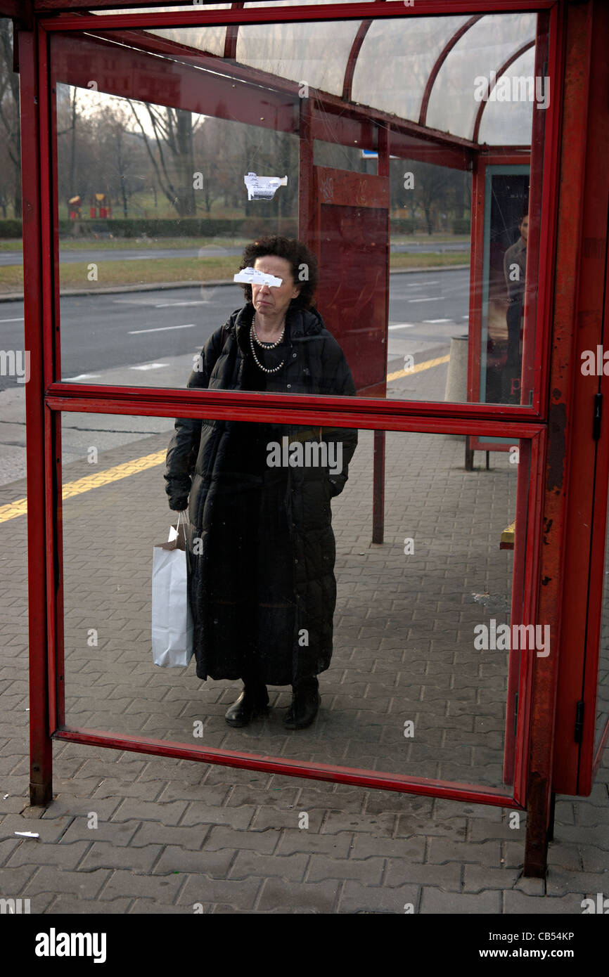 woman at bus stop in warsaw poland Stock Photo